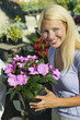 Woman Holding Flowers in plant nursery, portrait