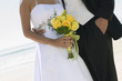 Bride and Groom with bouquet on beach, close-up