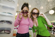 Two Girls Trying on Sunglasses in Boutique, portrait
