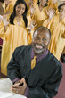 Minister at altar with Bible, gospel choir in background, portrait
