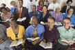 Photo: Church congregation sitting on church pews with Bible, portrait, high angle view Church congregation sitting on church pews with Bible, portrait, high angle view