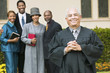 Smiling Preacher in church garden, worshipers in background, portrait
