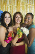Well-dressed teenage girls showing corsages at school dance, portrait
