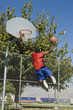 Basketball player, mid-air, shooting ball, back view