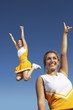 Cheerleaders cheering and jumping, mid-air, low angle view