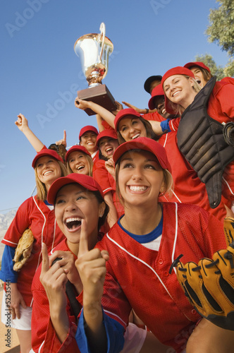 Photo: Women's softball team with trophy, portrait, low angle view Women's softball team with trophy, portrait, low angle view