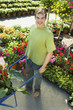 Young man with pushcart in garden centre, portrait, elevated view