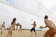 Man Hitting Volleyball during Game on Beach