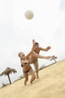 Couple Diving for Volleyball on Beach