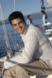 Young man on sailboat, friends in background, portrait