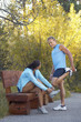 Couple stretching before  run through woodland
