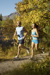 Couple jogging through woodland