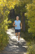 Man jogging along path in woodland