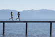 Women Jogging on Pier above Scenic Lake