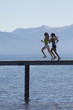 Women Jogging on Pier above Scenic Lake