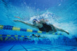 Female swimmers racing underwater in pool