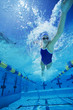 Female swimmer racing underwater in pool
