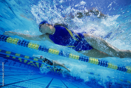 Photo: Underwater view female swimmers racing Underwater view female swimmers racing