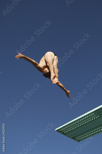Photo: Male diver diving from board, mid air Male diver diving from board, mid air