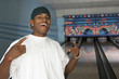 Young man at bowling alley celebrating, portrait