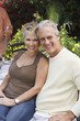Photo: Affectionate middle aged couple sitting outdoors Affectionate middle aged couple sitting outdoors