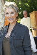 Elegant mature woman smiling, standing outdoors