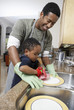 Son 3-6 helping father wash dishes