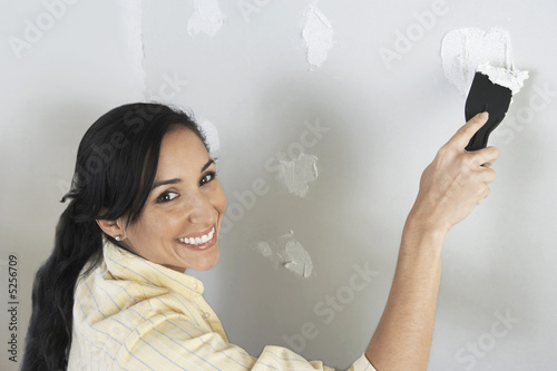 Photo: Woman speckling interior wall, elevated view Woman speckling interior wall, elevated view