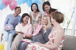 Woman Displaying a Gift at Her Baby Shower