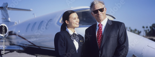 Foto: Businessman and Flight Crew Standing by Airplane Businessman and Flight Crew Standing by Airplane