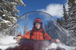 Photo: Woman driving snowmobile through snow, front view. Woman driving snowmobile through snow, front view.