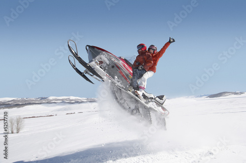 Photo: Couple Mid-air on Snowmobile Couple Mid-air on Snowmobile