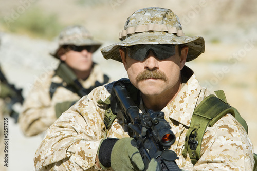 Photo: Soldier carrying rifle, outdoors Soldier carrying rifle, outdoors