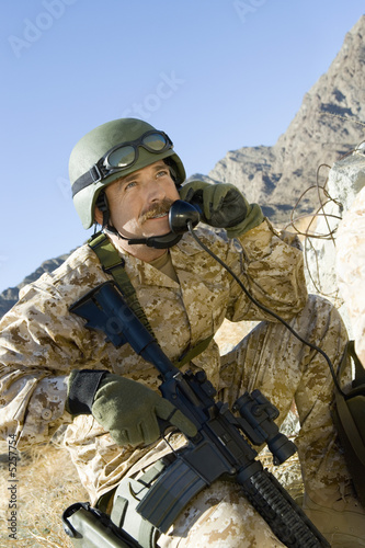 Photo: Soldier using field phone in mountains Soldier using field phone in mountains