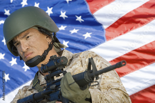 Photo: Soldier holding rifle in front of United States flag, portrait Soldier holding rifle in front of United States flag, portrait