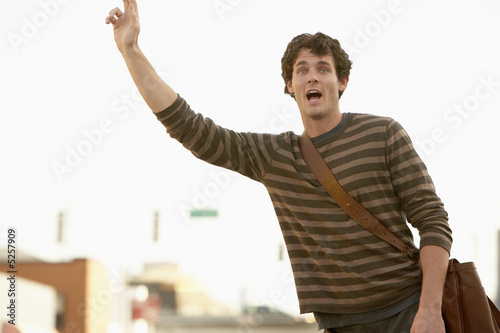 Photo: Man signalling taxi in street Man signalling taxi in street