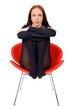Pretty girl seating on the red chair, isolate on white