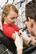 Woman getting tattoo.