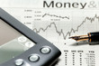 a stock market chart with a pen and pda