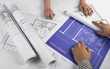 Architects working on blueprints Architects working on blueprints