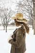 Foto: Brunette woman wearing straw cowboy hat in the snow. Brunette woman wearing straw cowboy hat in the snow.