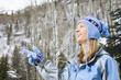 Foto: Blond woman wearing blue ski clothing smiling and pointing. Blond woman wearing blue ski clothing smiling and pointing.