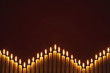 Row of lit candles, on black background