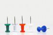 Row of five push pins facing up, one fallen over, close up