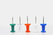 Row of five push pins with points facing up, close up
