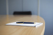 Foto: Ballpoint pen and notepad on conference table Ballpoint pen and notepad on conference table