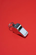 Whistle on red background in studio