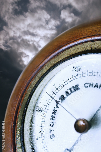 Photo: Barometer in front of cloudy sky, digital composite Barometer in front of cloudy sky, digital composite