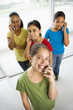 Photo: Preteen girls talking on cell phones and looking at viewer. Preteen girls talking on cell phones and looking at viewer.