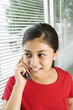 Photo: Hispanic preteen girl talking on cell phone. Hispanic preteen girl talking on cell phone.